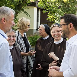 Personengruppe im Gespräch mit Ordensschwestern